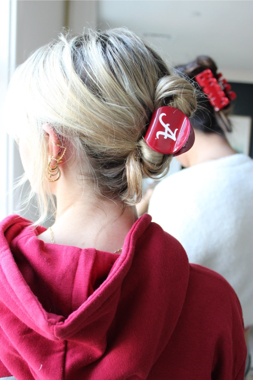 Young woman wearing Alabama licensed collegiate claw clip in her blonde hair 