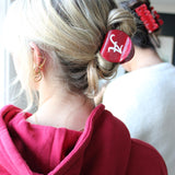 Young woman wearing Alabama licensed collegiate claw clip in her blonde hair 